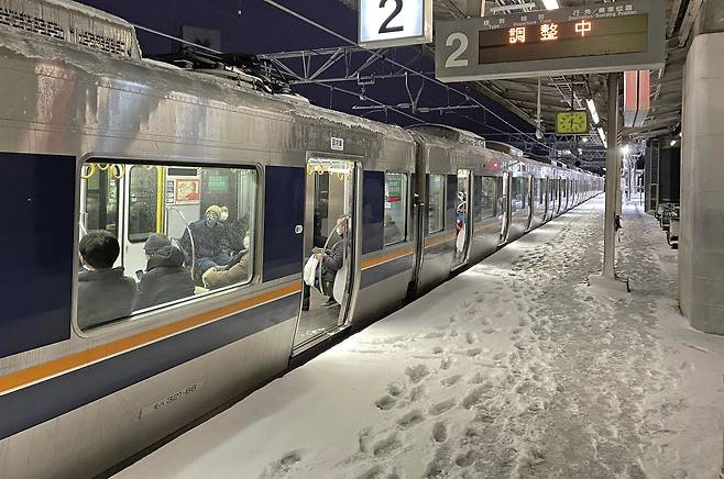 25일 일본 서부 교토의 니시오지역에서 정전으로 열차가 멈춰 서 있다. 일본의 대부분 지역에 내린 눈과 한파로 고속도로, 항공, 기차 운행에 차질을 빚었다. 교토=AP 뉴시스