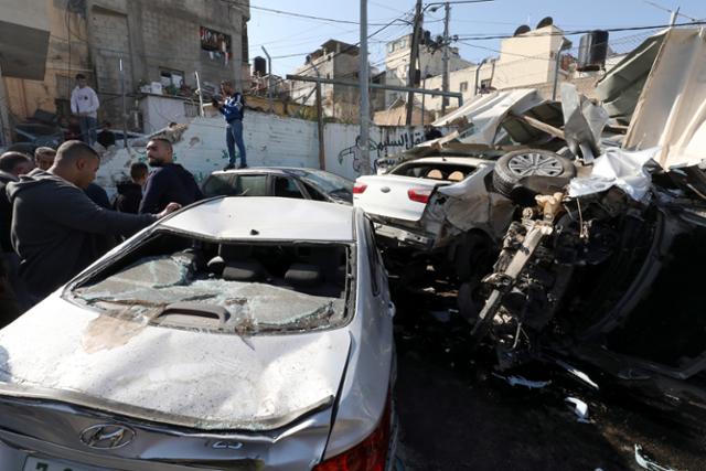 26일(현지시간) 요르단강 서안지구 제닌 난민촌에서 이스라엘군의 공격 이후 팔레스타인 주민들이 부서진 차량을 조사하는 모습. 제닌=EPA 연합뉴스