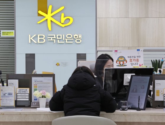 KB국민은행 영업점 창구에서 고객이 은행 일을 보는 모습. 연합뉴스
