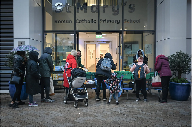 영국 런던 배터시 인근의 한 초등학교에서 푸드뱅크 관계자가 음식과 생활용품을 나눠주고 있다. <사진=뉴욕타임스>