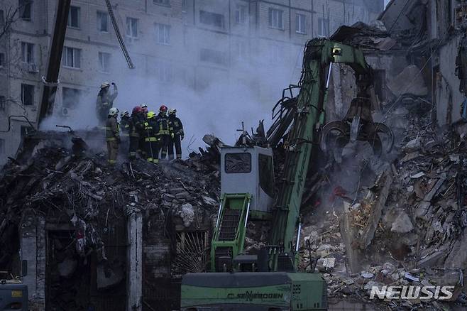 [드니프로=AP/뉴시스] 1월15일(현지시간) 우크라이나 남동부 도시 드니프로에서 구조대가 러시아군의 로켓 공격으로 파괴된 아파트 건물 잔해를 치우고 있다. 2023.01.16.