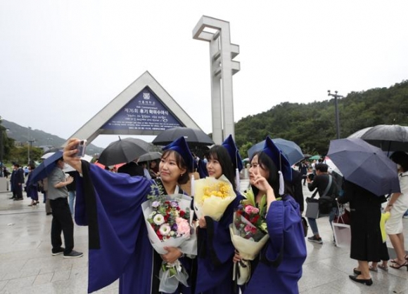 서울 관악구 서울대학교에서 지난해 8월에 열린 제76회 후기 학위수여식을 마친 졸업생들이 교문 앞에서 기념사진을 찍고 있다. 연합뉴스