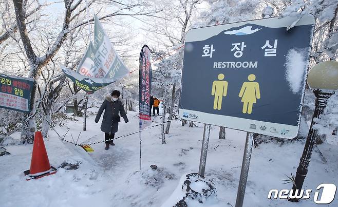 지난 25일 오후 한 관광객이 사용이 금지된 110고지 습지 화장실 앞에 쳐진 통제선을 넘고 있다. 2023.1.25/뉴스1