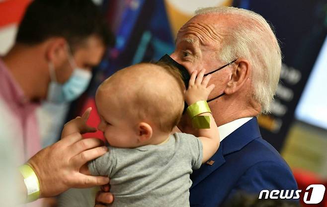 조 바이든 미국 대통령이 21일(현지시간) 워싱턴의 교회에 마련된 코로나19 백신 클리닉에서 접종을 하러 온 5세 미만 영유아를 안고 있다. ⓒ AFP=뉴스1 ⓒ News1 우동명 기자