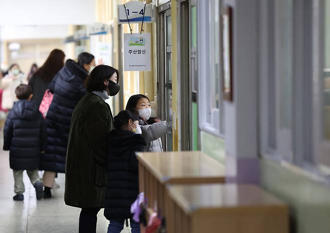 지난 4일 서울 마포구의 한 초등학교 예비소집에 참석한 예비 초등학생과 학부모들이 마스크를 쓴 채 교실을 둘러보고 있다. 연합뉴스
