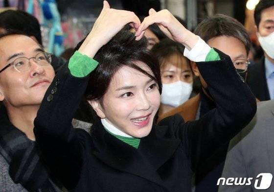 김건희 여사가 지난 11일 대구 서문시장을 방문해 시민들에게 머리 위로 손하트를 만들어보이고 있다. 뉴스1