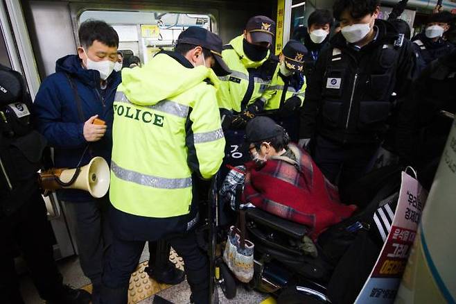 전국장애인차별철폐연대(전장연)가 출근길 지하철 탑승 기습 시위를 벌인 3일 오전 서울 중구 지하철 4호선 동대문역사문화공원역에서 서울교통공사 관계자와 경찰에게 지하철 탑승을 저지당하고 있다. 사진 = 임형택 기자&nbsp;