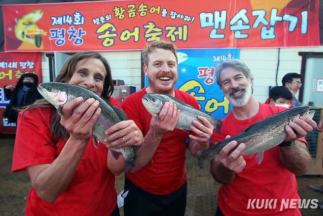 2023 평창송어축제 '송어 맨손잡기’ 이벤트에 참가한 외국인 관광객들이 송어를 들고 기념촬영을 하고 있는 모습.