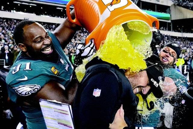 필라델피아 수비수 플레처 콕스(왼쪽)가 30일 안방에서 열린 미국프로미식축구리그(NFL) 내셔널풋볼콘퍼런스(NFC) 챔피언결정전 승리로 슈퍼볼 진출을 확정한 뒤 닉 시리아니 감독에게 음료수를 부으며 기뻐하고 있다. 필라델피아·캔자스시티=AP 뉴시스