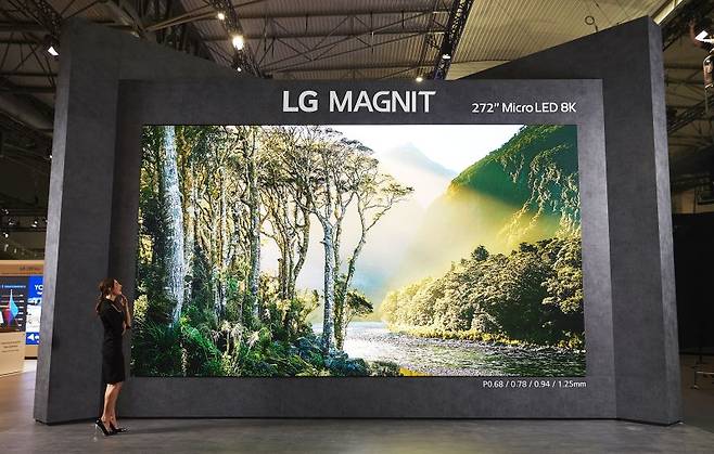 LG전자 모델이 ISE 2023 LG전자 전시관 입구에 설치된 8K 272형 마이크로 LED 사이니지 'LG 매그니트'로 영상을 감상하고 있다. LG전자 제공