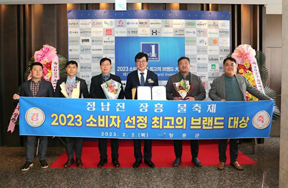 전라남도 장흥군 관계자들이 올해 정남진 장흥 물축제 소비자 선정 최고의 브랜드 대상 수여 관련 현수막을 들고 기념촬영하고 있다. [사진=장흥군]