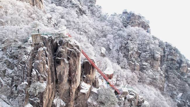 눈꽃에다 상고대까지 피어난 날의 대둔산 풍경. 온통 순백의 풍경 속에서 사다리처럼 가파르게 놓인 삼선계단을 타고 왕관바위에 오른 등산객의 모습이 마치 수묵화에 점 하나를 찍은 듯하다.