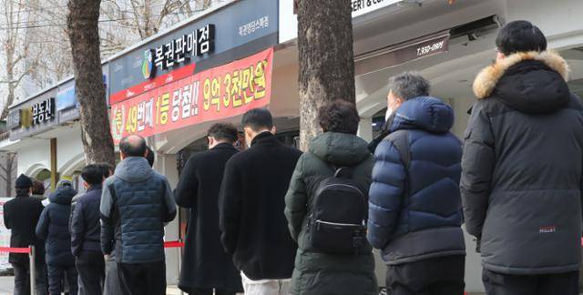 설 명절을 앞둔 1월 19일 서울 노원구 한 복권판매점 앞에 복권을 사기 위한 시민들이 길게 줄 서 있다. 뉴스1