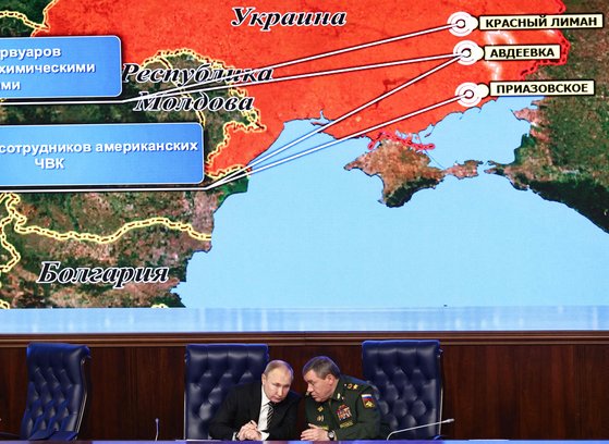 블라디미르 푸틴 러시아 대통령(왼쪽)과 발레리 게라시모프 러시아군 총참모장이 지난 2021년 12월 21일 연례 회의에서 우크라이나 지도를 보여주는 대형 스크린 앞에 앉아 대화하고 있다. 그로부터 두달 후 러시아는 우크라이나를 침공했다. AFP=연합뉴스