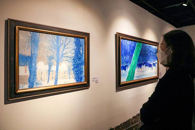 앙드레 브라질리에의 ‘멈추어라, 순간이여!’ 특별전에 전시된 그림 <눈 오는 마세의 작은 성>을 관람객이 감상하고 있다./한수빈 기자