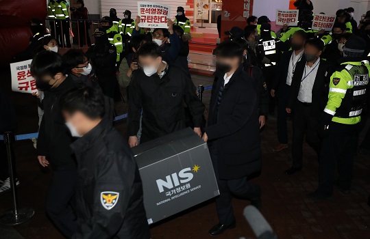 국정원 관계자들이 지난달 18일 오후 민노총 서울 사무실을 압수수색한 후 압수품 상자를 들고 나가고 있다. (사진 = 뉴스1)