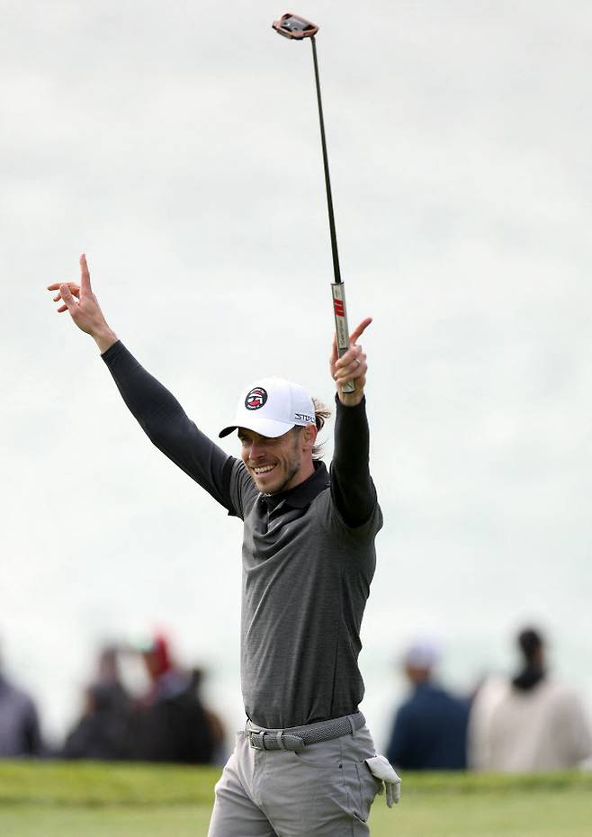 개러스 베일이 6일 열린 3라운드 잔여 경기에서 퍼트에 성공한 뒤 두 팔을 번쩍 들며 기뻐하고 있다.(사진=AFPBBNews)