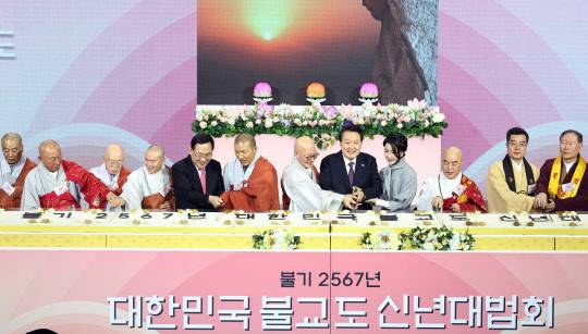 윤석열 대통령과 김건희 여사가 6일 서울 강남구 코엑스에서 열린 불기 2567년 대한민국 불교도 신년대법회에서 떡케이크를 자르고 있다. 연합뉴스