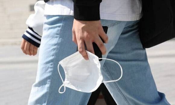 한 학생이 마스크를 들고 이동하고 있다. 연합뉴스