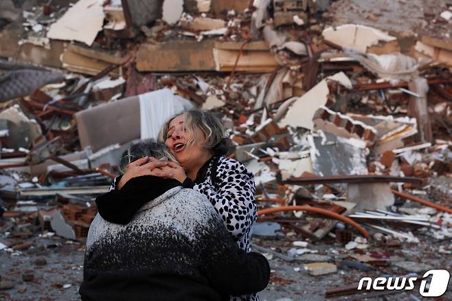 7일 튀르키예(터키) 남동부 하타이에서 강진으로 무너진 건물 앞에서 시민들이 서로 껴안으며 통곡하고 있다. ⓒ 로이터=뉴스1 ⓒ News1 박재하 기자