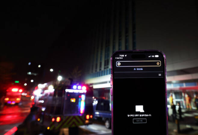 지난 해 10월 15일 화재가 발생한 SK 판교 데이터센터 앞에서 스마트폰 다음 애플리케이션에 오류 메시지가 표시되고 있다. (사진=연합뉴스)