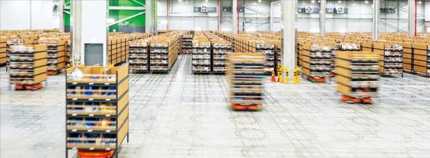 쿠팡 대구 풀필먼트센터(FC)에서 로봇이 분주하게 선반을 옮기고 있다. 대구FC는 근로자들이 고정된 선반에 있는 상품을 운반하는 게 아니라 로봇이 선반을 근로자가 있는 곳으로 가져다주는 시스템이 적용됐다.   쿠팡  제공