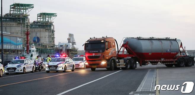 (제주=뉴스1) 오현지 기자 = 민주노총 공공운수노조 화물연대본부 총파업 후 처음으로 제주지역에 시멘트가 반입된 8일 오전 제주시 애월항에서 벌크시멘트트레일러(BCT) 차량이 경찰 호위를 받으며 이동하고 있다. 2022.12.8/뉴스1  Copyright (C) 뉴스1. All rights reserved. 무단 전재 및 재배포 금지.