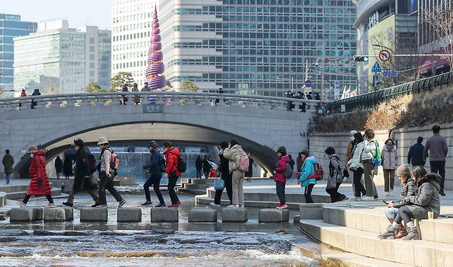서울 낮 최고 기온이 7도까지 오른 8일 서울 중구 청계천 일대에서 시민들이 산책을 즐기고 있다.   뉴스1