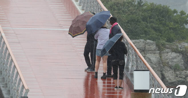 제주 서귀포시 새연교를 찾은 관광객들이 우산을 쓰고 이동하고 있다.(뉴스1DB)ⓒ News1 오현지 기자