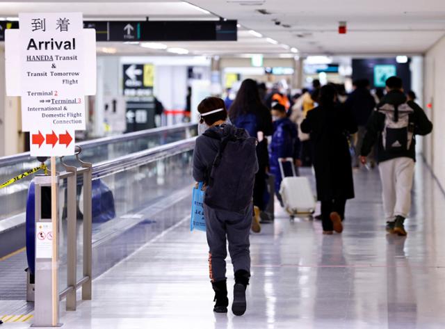 지난 1월 12일 일본 나리타 국제공항에 도착한 중국 다롄발 여객기 승객들이 코로나19 검사 구역으로 향하고 있다. 나리타=로이터 연합뉴스