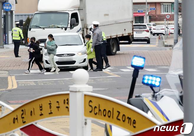 제주경찰이 9일 오후 제주시 이도초등학교 어린이보호구역에서 보행자 보호의무 위반 행위를 단속하고 있다. 개정 도로교통법에 따라 어린이 보호구역 내 신호기가 없는 횡단보도에서는 보행자 유무와 관계없이 일시정지해야 한다. 2023.2.9/뉴스1 ⓒ News1 오현지 기자