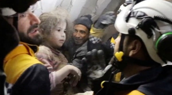 시리아 민간구조대인 '하얀 헬멧' 대원들이 8일(현지시간) 건물 잔해에서 여자 아이를 구조한 뒤 안고 있다. /사진=로이터