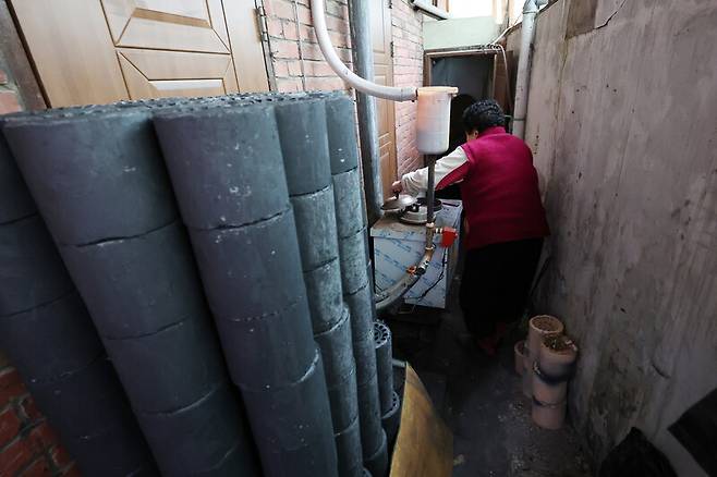 지난달 26일 오후 광주 동구 지산2동 한 주택에서 난방 취약계층 노인이 연탄불을 살펴보고 있다. 연합뉴스