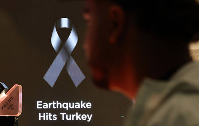 튀르키예 이스탄불 국제공항 입국장 내 면세점의 한 전광판에 지진 피해 희생자들을 추모하는 검은 리본이 표시되고 있다. <연합뉴스>