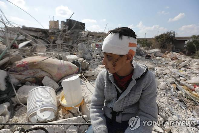 가족 잃고 잔해 더미에 앉아있는 시리아 소년 (진데리스[시리아] AFP=연합뉴스)