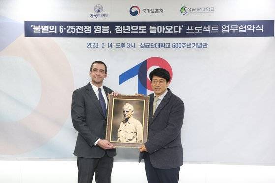 14일 오후 서울시 종로구 성균관대 600주년 기념관에서 열린 6.25참전영웅 AI기술활용 복원사업 업무협약식에서 신민식 자생의료재단 사회공헌위원장이 6.25 참전유공자 故에드워드 포니의 증손자 벤자민 포니에게 AI로 복원한 영웅의 사진액자를 전달하고 있다. 사진 국가보훈처
