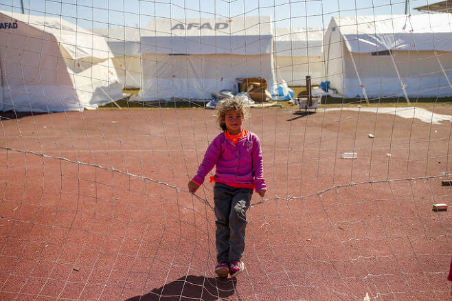 13일(현지시간) 튀르키예 아디야만에 마련된 이재민용 텐트촌에서 한 소녀가 카메라를 보며 웃고 있다.  아디야만=AP/뉴시스