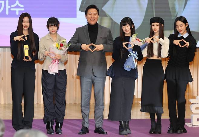 오세훈 서울시장이 16일 오전 서울시청에서 열린 ‘서울특별시 홍보대사 위촉식’에서 뉴진스에게 위촉패를 전달한 뒤 기념사진을 촬영했다. 오 시장의 얼굴에 웃음이 가득했다. [자료 = 연합뉴스]