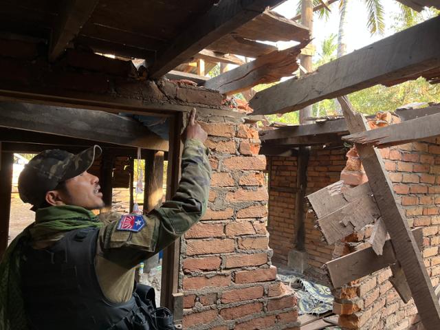 지난달 31일 미얀마 코커레이크주 총도 인근에서 시민방위군이 이틀 전 미얀마군의 폭격으로 무너져 내린 집을 가리키고 있다. 총도(미얀마)=허경주 기자
