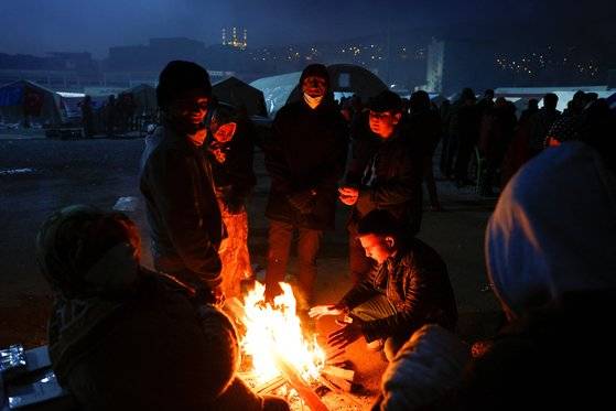 강진으로 집을 잃은 이재민들이 14일 튀르키예 카라만마라슈의 피난민 캠프 주변에서 불을 피워 추위를 이겨내고 있다. 로이터=연합뉴스