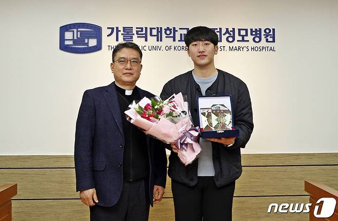 강전용 대전성모병원장(왼쪽)이 21일 김대흥씨에게 감사패를 전달한 후 기념촬영을 하고 있다. (대전성모병원 제공) /뉴스1