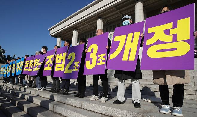 21일 오전 국회 본관 앞 계단에서 노조법2·3조 개정 운동본부 기자회견이 열려 참석자들이 법안의 온전한 국회 통과를 촉구하는 손팻말을 들고 있다. 신소영 기자