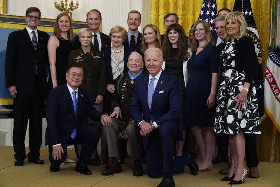 조 바이든 대통령(앞줄 가운데)과 문재인 당시 대통령(앞줄 왼쪽)이 2021년 5월 21일 워싱턴 백악관 이스트룸에서 전직 미 육군 대령 랄프 퍼켓의 명예훈장 수여식에서 기념촬영을 하고 있다. 문 대통령은 당시 질 바이든여사(오른쪽 끝)에게 스님들의 손수건과 앨범 등을 선물했다. AP=연합뉴스