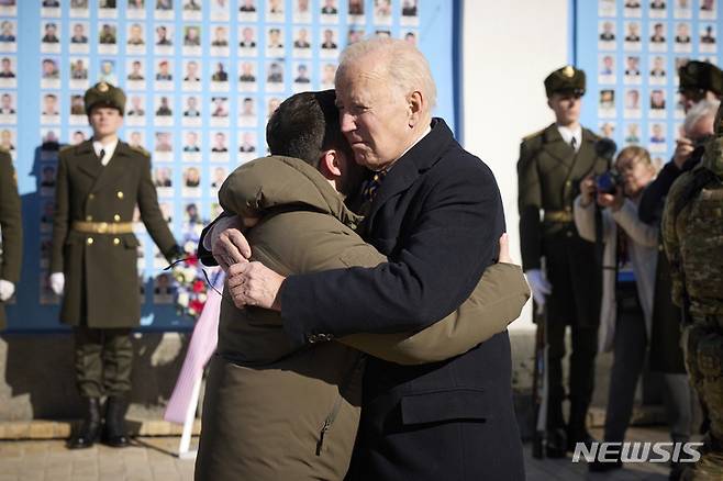 [키이우=AP/뉴시스] 조 바이든(오른쪽) 미국 대통령이 20일(현지시간) 우크라이나 키이우를 깜짝 방문해 러시아-우크라이나 전쟁에서 전사한 군인들의 사진이 붙어 있는 추모의 벽에 헌화한 후 볼로디미르 젤렌스키 우크라이나 대통령과 작별 인사를 하고 있다. 2023.02.21.