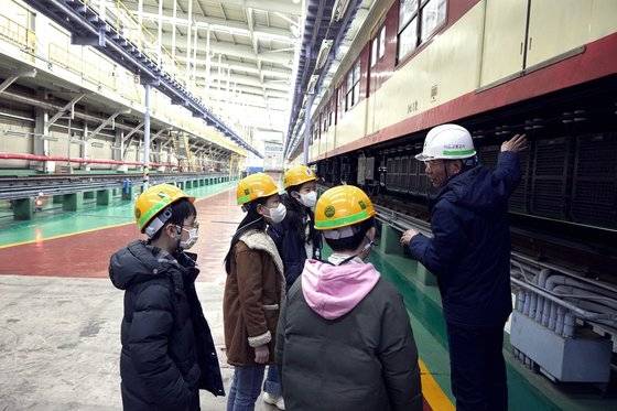 김용민 서울교통공사 군자 차량 사업소 시설팀 팀장(맨 오른쪽)이 소중 학생기자단에게 1세대 저항제어 전동차를 통해 전동차 정비와 검사 과정을 공개했다.