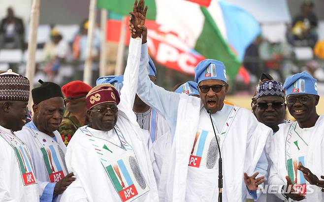 [라고스=AP/뉴시스] 무하마두 부하리(오른쪽) 나이지리아 대통령이 21일(현지시간) 나이지리아 라고스에서 열린 집권 여당 '범진보의회당'의 볼라 티누부 대선 후보의 선거 유세에 참석해 티누부 후보의 손을 들어주고 있다.