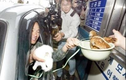 2003년 인천공항 고속도로 통행료 인하 시위에서 영종도 주민이 통행료를 현금 대신 닭으로 내고 있다.|인천공항 고속도로 통행료 인하추진위원회 제공