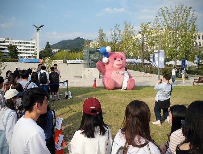 Students queue in front of Bellygom to take pictures at Yonsei University's Sinchon campus on Thursday. [ALLAND DHARMAWAN]