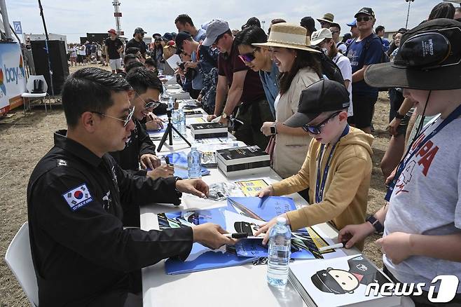 4일(현지시간) 호주 맬버른 애벌론 공항에서 열린 '2023 호주 애벌론 국제에어쇼'에서 대한민국 공군 특수비행팀 블랙이글스(Black Eagles) 비행팀장 1번기 조종사 양은호 소령이 관람객에게 기념 사인을 해주며 대화하고 있다. (공군 제공) 2023.3.5/뉴스1