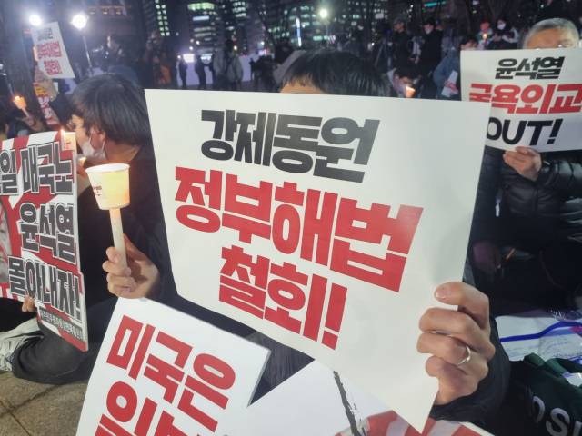 ▲6일 저녁 정부의 강제동원 해법 강행을 규탄하는 긴급촛불집회에서 한 시민이 피켓을 들어올리고 있다. ⓒ프레시안(한예섭)